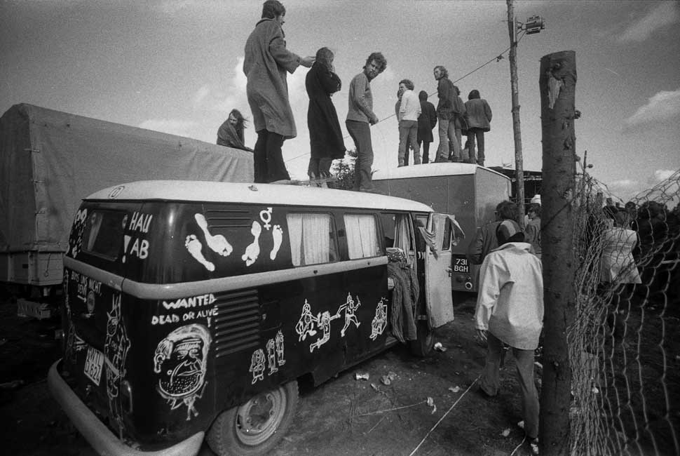 Fans clamber on top of a van for a better view