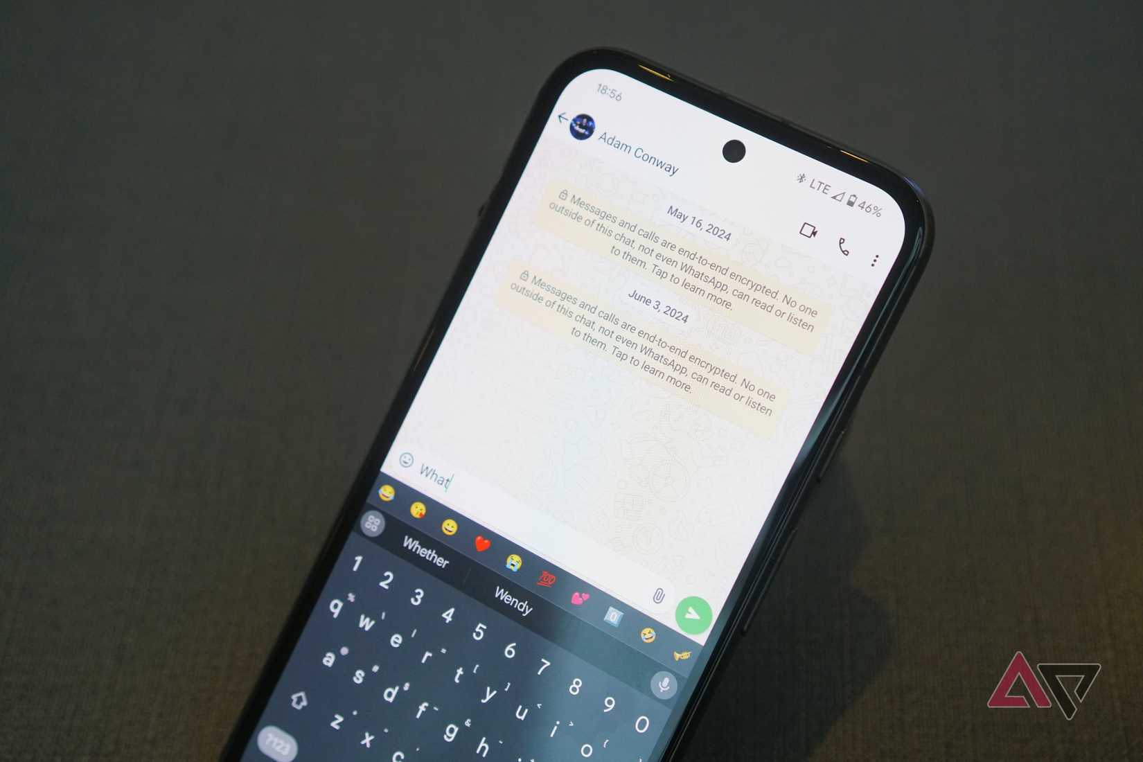 A smartphone with a WhatsApp message to Adam Conway on the screen.