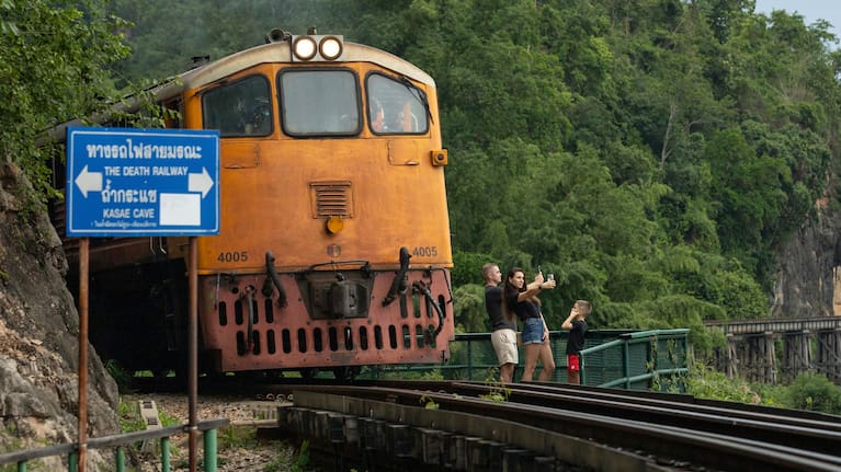 A family of Russian tourists pose for photos as a train approaches Thamkra Sae Station, one of the still active sections of the infamous World War II "Death Railway," in Sai Yok, Thailand, Thursday, May 28, 2026