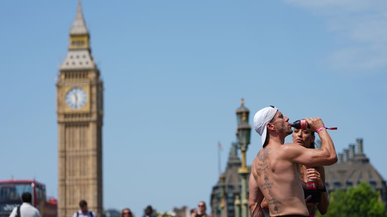 A man drinks on Westminster Bridge in London, as a heat wave is predicted Tuesday, June 23, 2026.