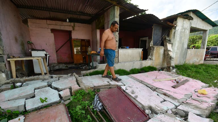 A man walks over the fallen walls of his home in Moron, near the epicenter of two earthquakes that struck Venezuela the day before.