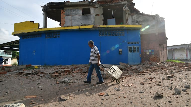 A man walks past a damaged home in Moron, near the epicenter of two earthquakes that struck Venezuela the day before, Thursday, June 25, 2026.