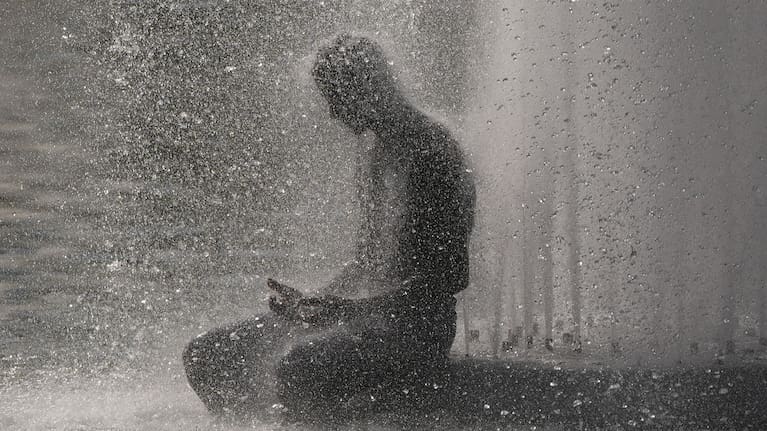 A person cools off at Trocadero fountain near the Eiffel Tower during a heat wave in Paris.