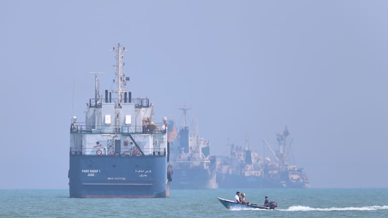 A small motorboat passes anchored vessels in the Strait of Hormuz off Bandar Abbas, Iran, Thursday, June 11, 2026.