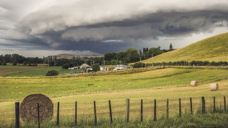 A thunderstorm brewing over hills in rural New Zealand.