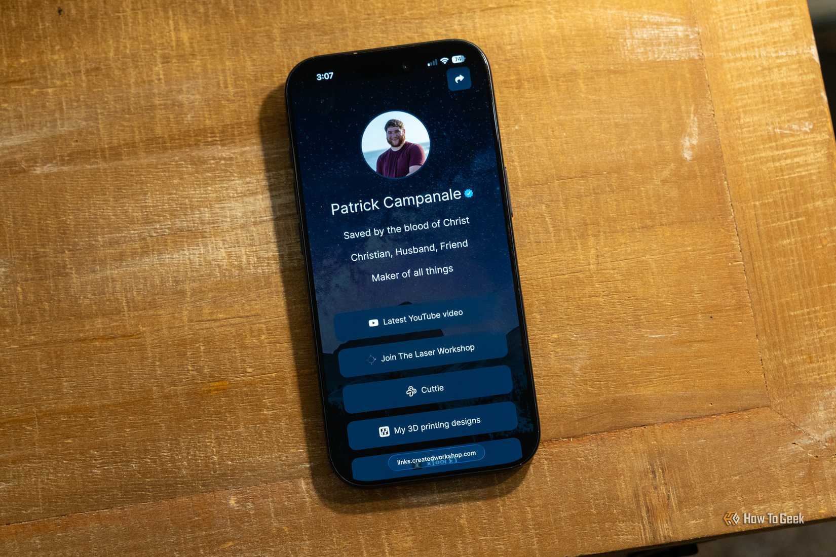 A LinkStack landing page being shown on an iPhone 17 Pro sitting on a wooden desk.
