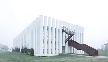 vertical white pillars compose rhythmic school facade in italy