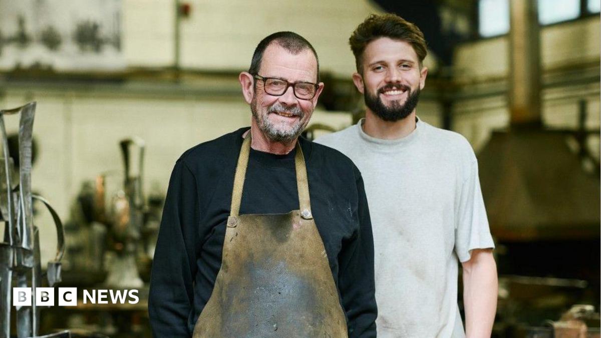 Brian Fell (L) has short cropped brown hair, brown glasses and wears a black sweat shirt and stained khaki apron while George Fell (R) has brown hair and beard and wears a  grey T-shirt.