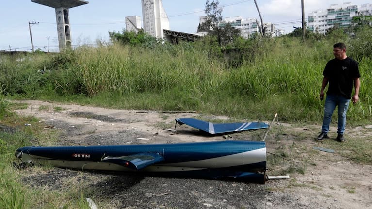 Aircraft debris lies near the site where two helicopters reportedly collided in midair and crashed into a car dealership parking lot in Rio de Janeiro, Brazil.