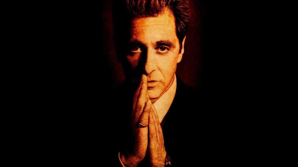 Al Pacino rubbing his hands together on the poster for The Godfather Part III