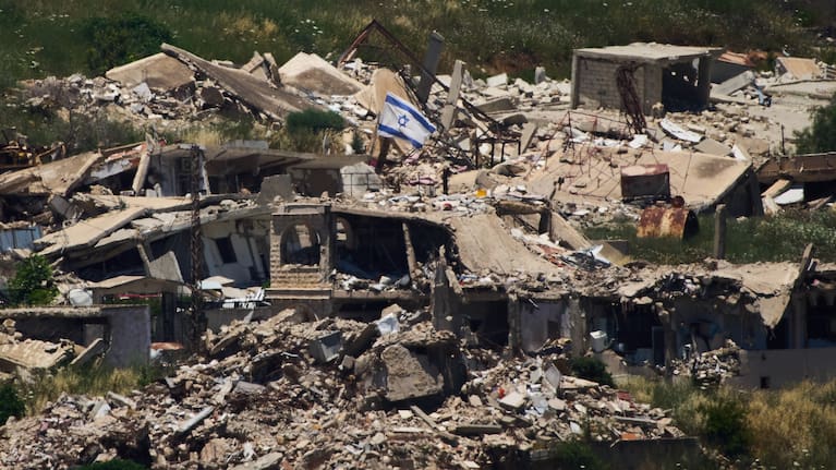 An Israeli flag hangs on a destroyed building in southern Lebanon as seen from northern Israel, Thursday June 4, 2026.