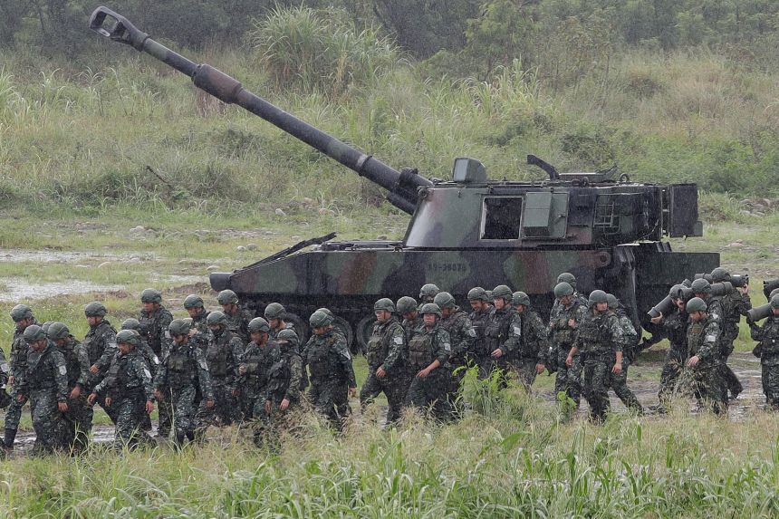 Soldiers move past a self-propelled howitzer during a military live-fire shooting training in Taichung City, Taiwan, Tuesday, June 9.