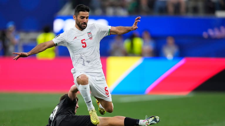Iran's Milad Mohammadi (5) jumps over New Zealand's Callum McCowatt (20) during the World Cup Group G soccer match between Iran and New Zealand.