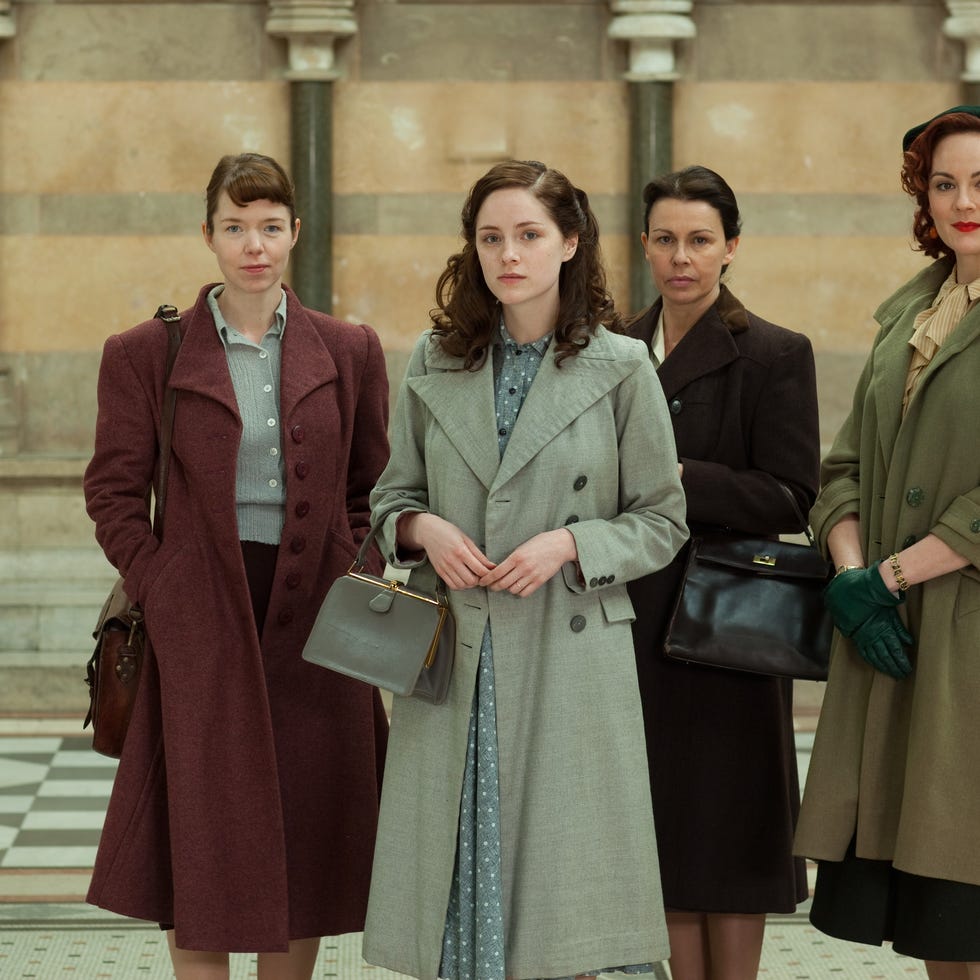 four women in vintage clothing stand together in a historical setting four women in vintage clothing stand together in a historical setting