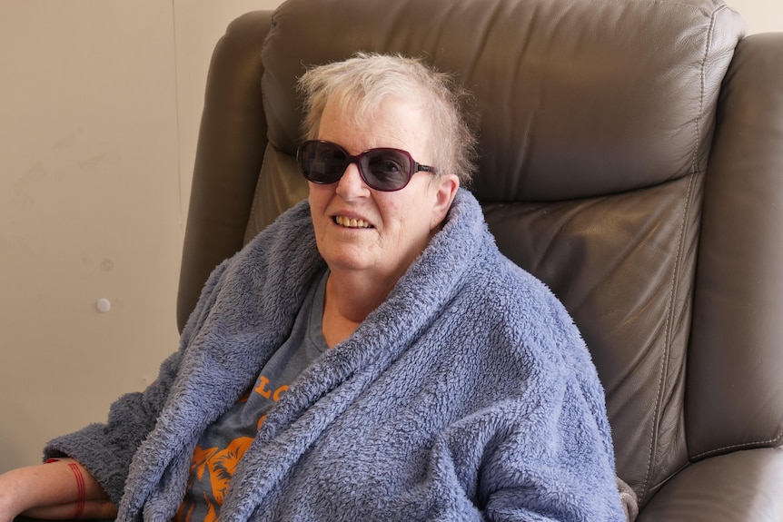 A woman in sunglasses sitting on an armchair