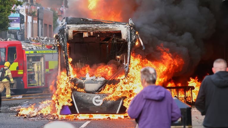 People watch as firemen arrive to put out vehicle that was set alight during a protest in East Belfast following a stabbing incident in Belfast, Tuesday, June 9, 2026