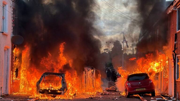 Vehicles set on fire by protesters burn on Lendrick Street in east Belfast, Northern Ireland, on Tuesday, June 9, 2026, after the arrest of a Sudanese man accused of stabbing a man in the northern part of the city.