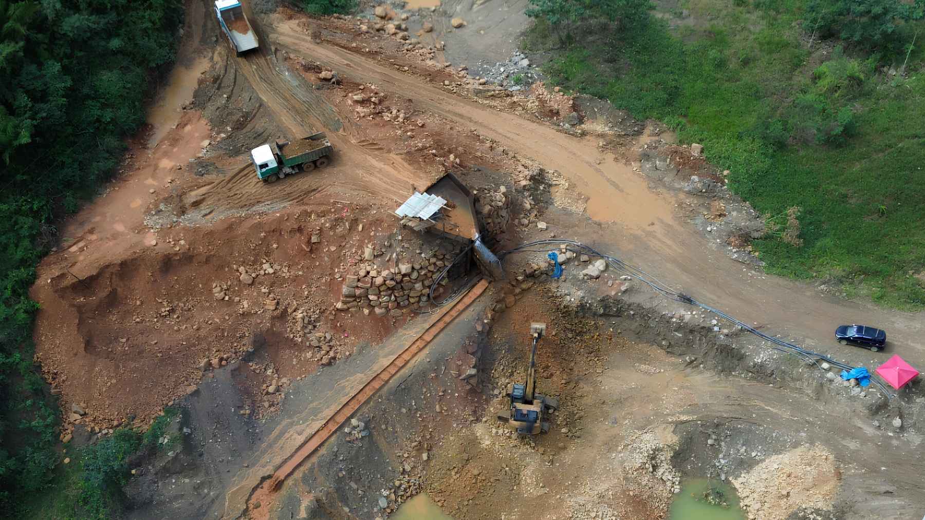 Aerial view of gold mining dredges operating in a muddy Amazon river in Bolivia, showing sediment pollution.
