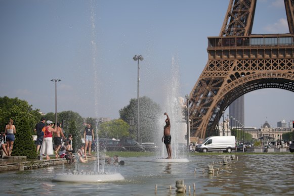 People cool off at Trocadero fountain near the Eiffel Tower during a heat wave in Paris on Wednesday.