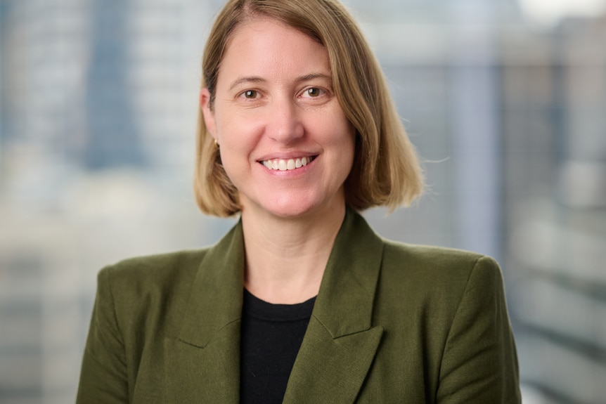 A smiling, fair-haired woman in a blazer.