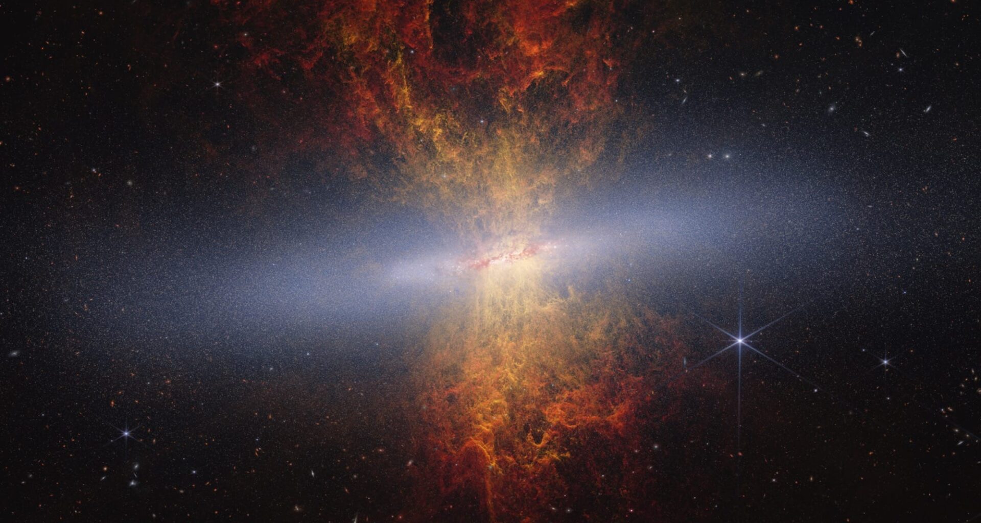 an image of an orange galaxy with a light through it