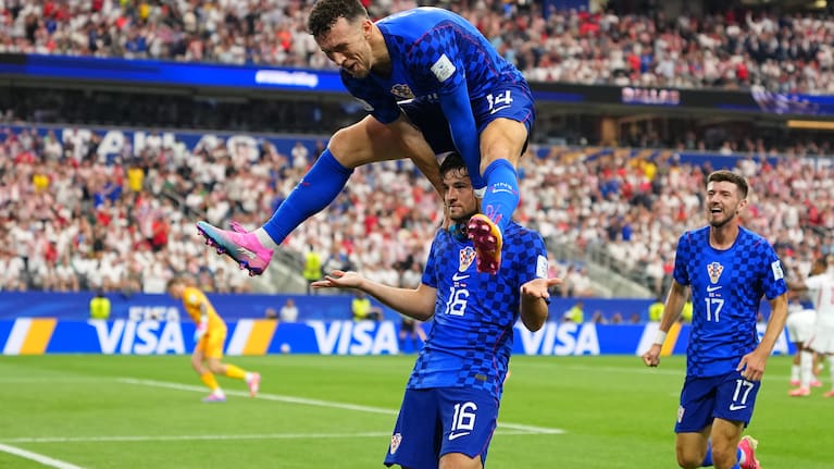 Croatia's Martin Baturina, bottom, is congratulated after scoring his side's first goal by Ivan Perisic after scored during the World Cup Group L match between England and Croatia in Arlington, Texas