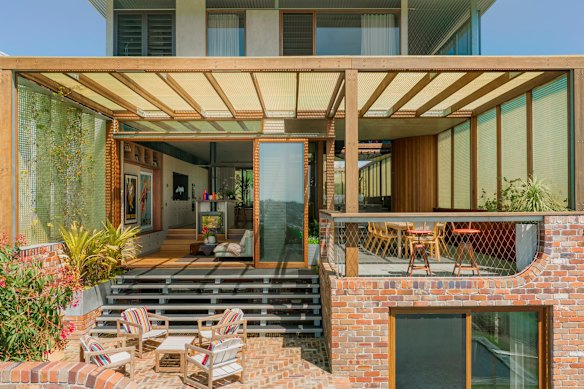 The house follows the fall of the land with terraced brick outdoor areas softened by landscaping. 