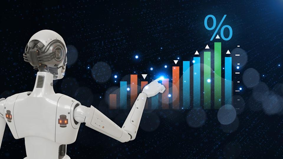 A white humanoid robot is shown from the back and right side, extending its right arm with its index finger touching a glowing point on a vibrant, upward-trending bar graph. The graph features blue, orange, and green bars with white trend indicators, topped by a large blue percentage symbol. The background is a dark, sparkling blue with scattered bokeh lights, creating a futuristic and data-driven atmosphere.
