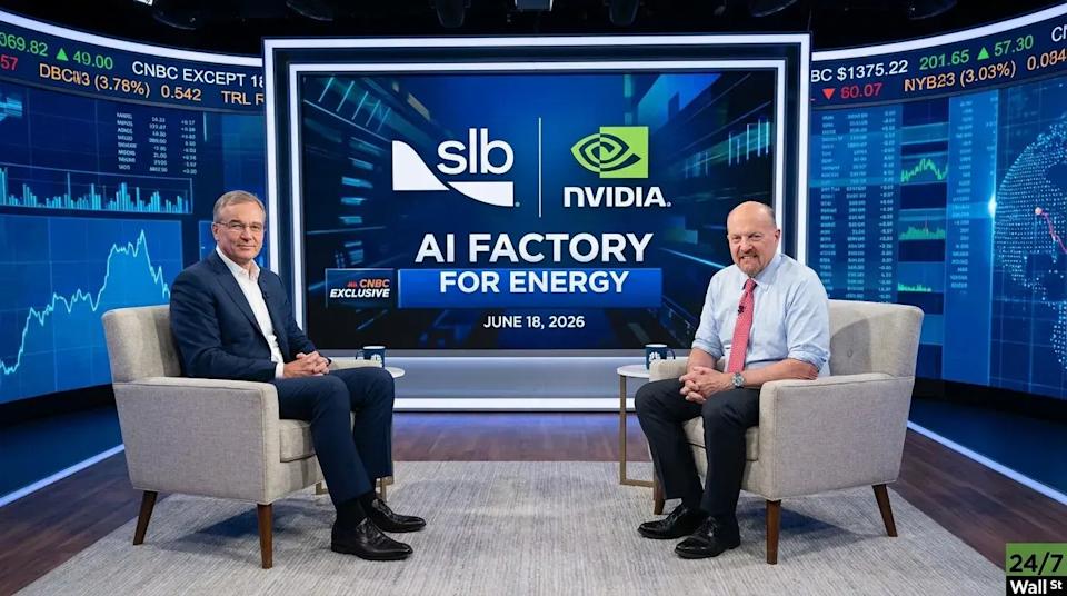 Two men in business attire sit in gray armchairs, facing each other in a television studio. A large central screen behind them displays the white SLB logo and the green NVIDIA logo, with bold white text reading 'AI FACTORY FOR ENERGY' and 'JUNE 18, 2026'. Curved screens on either side show blue financial market data with green and white text. The man on the left wears a dark suit, white shirt, and glasses, while the man on the right wears a light blue shirt, red tie, and glasses.
