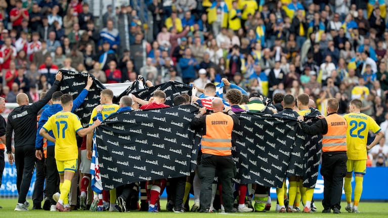 Players from Denmark and Ukraine accompany Christian Eriksen to a waiting ambulance