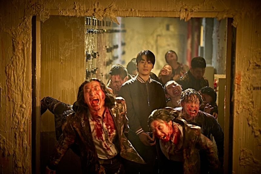 A man stands in the middle of a group of zombies