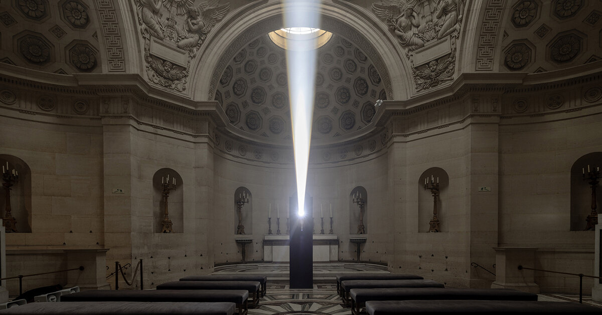 a beam of white light carves through paris' historical chapel
