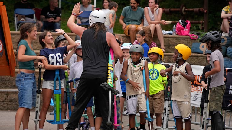 Extreme pogo athlete Harry White of Ontario, Canada, greets young neighborhood children.