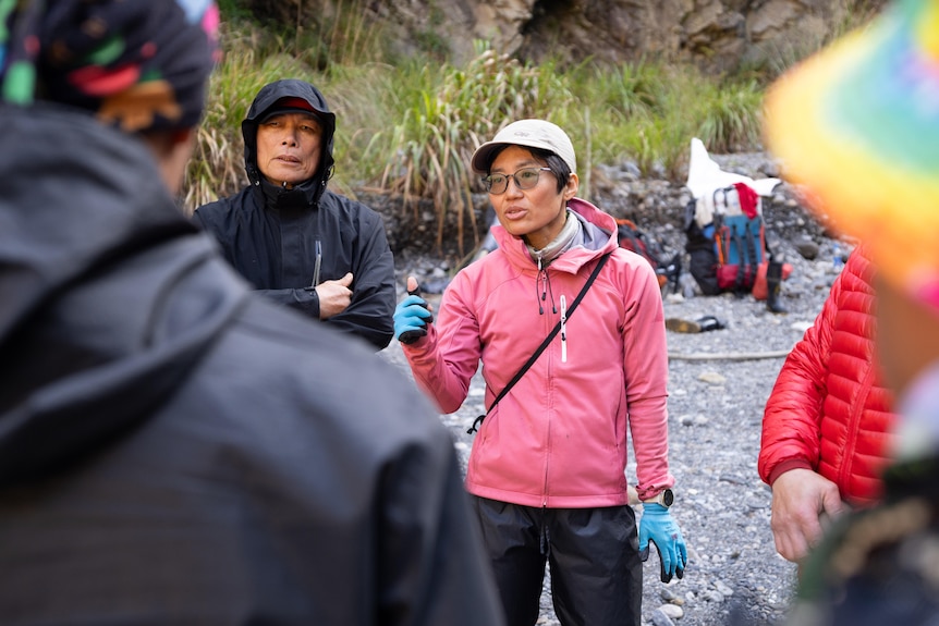 A woman in a pink rain jacket stands next to a man with a black jacket.