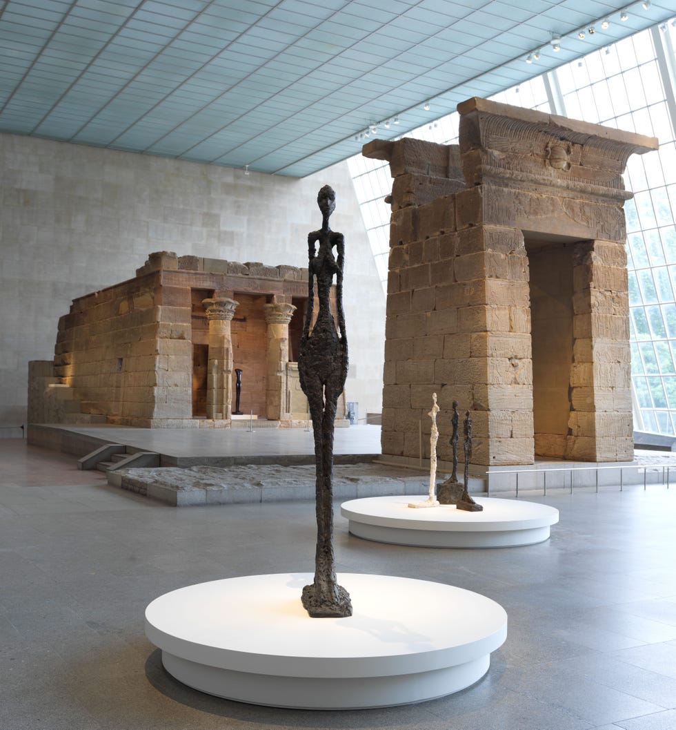 Ancient Egyptian temple with modern sculptures in museum gallery.