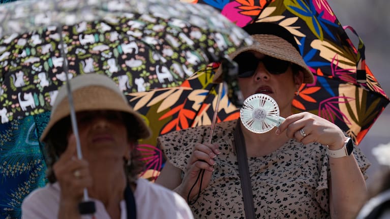 Faithful shelter from the hot sun as Pope Leo's XIV arrives for his weekly general audience in St. Peter's Square at The Vatican.