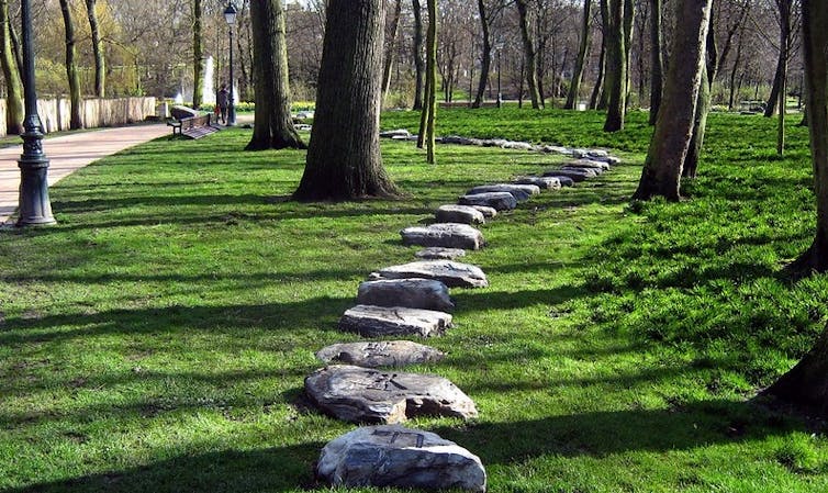 A stone path seen through trees.