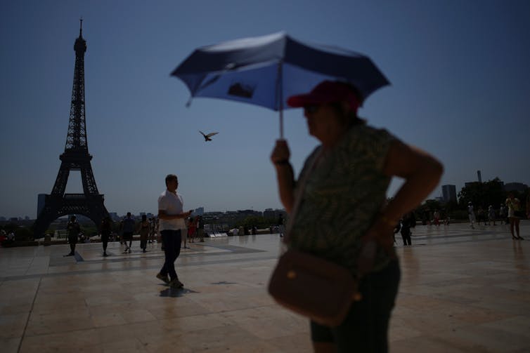 People walk at Trocadero plaza, near the Eiffel Tower, during a heatwave.