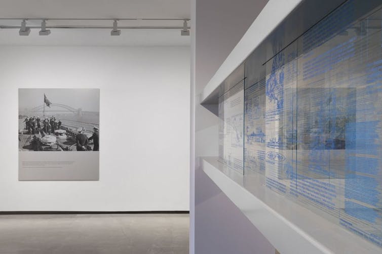 Two artworks: a black and white photograph, and blue writing on glass.