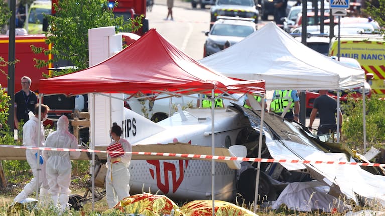 Forensic technicians examine a skydiving plane that crashed in Tomblaine northeastern France, killing all 11 people on board.