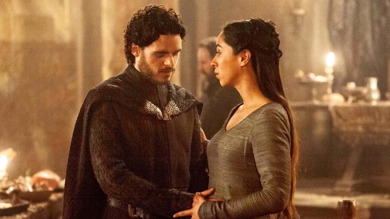 Robb Stark standing next to Talisa Stark as she speaks