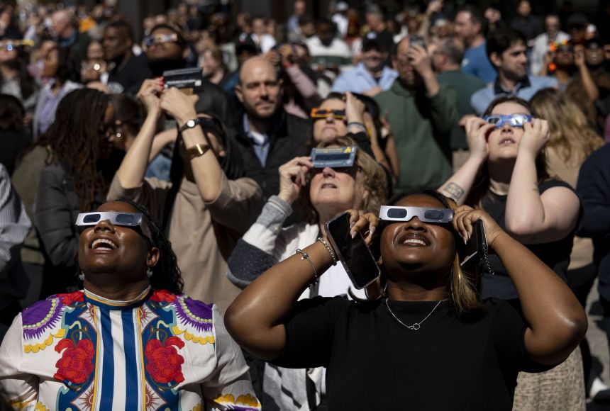 People look up to watch a partial solar eclipse in Chicago on April 8, 2024.