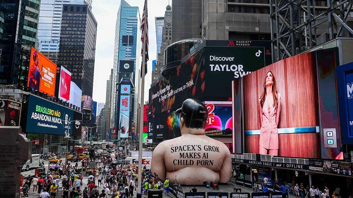 A giant inflatable effigy of Elon Musk in the middle of New York's Times Square, with the words "SpaceX's Grok makes AI child porn."