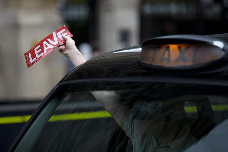 A taxi driver holds a sticker for the