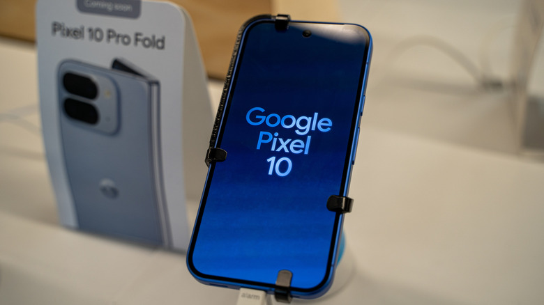 The Google Pixel 10 with a Pixel 10 Pro Fold poster in the background in a retail store