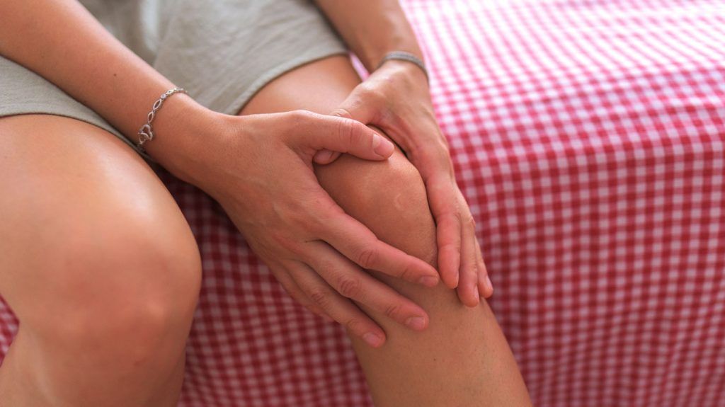 person holding their knee with both their hands