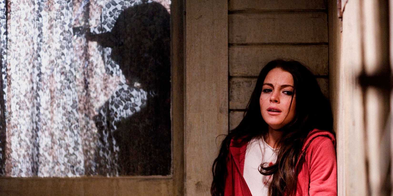 Lindsay Lohan hiding while a man stands outside her window in I Know Who Killed Me Shadow