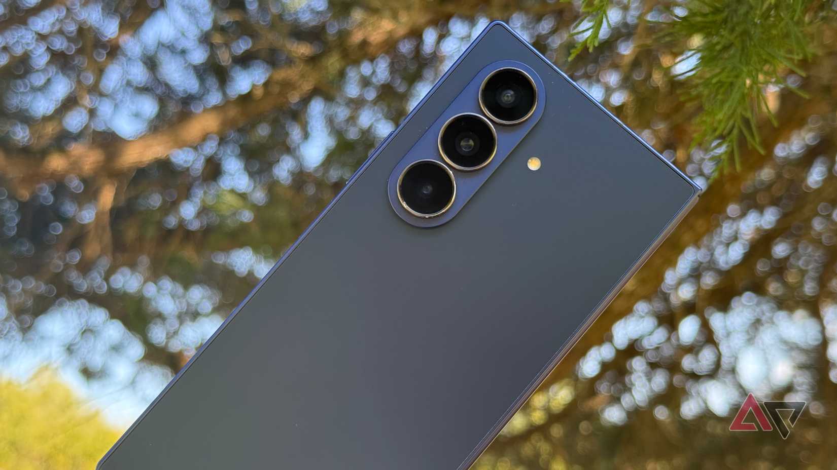 Samsung Galaxy Z Fold 7 held against a tree at dusk