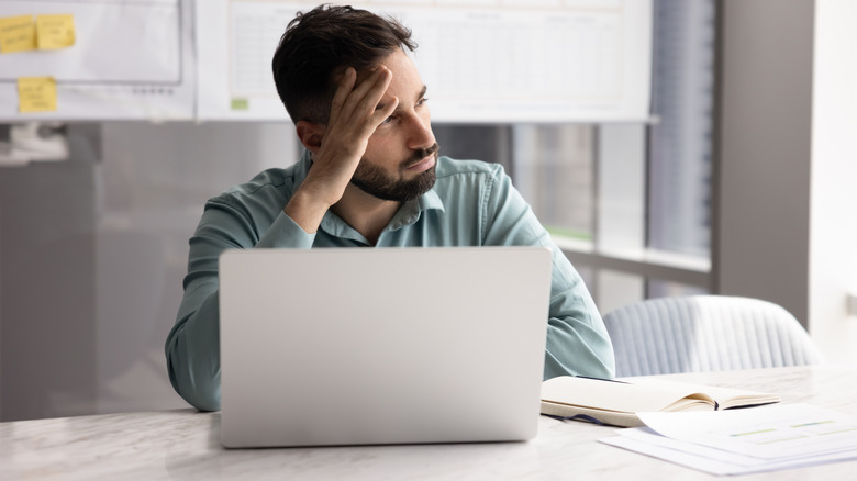 A frustrated man using a laptop