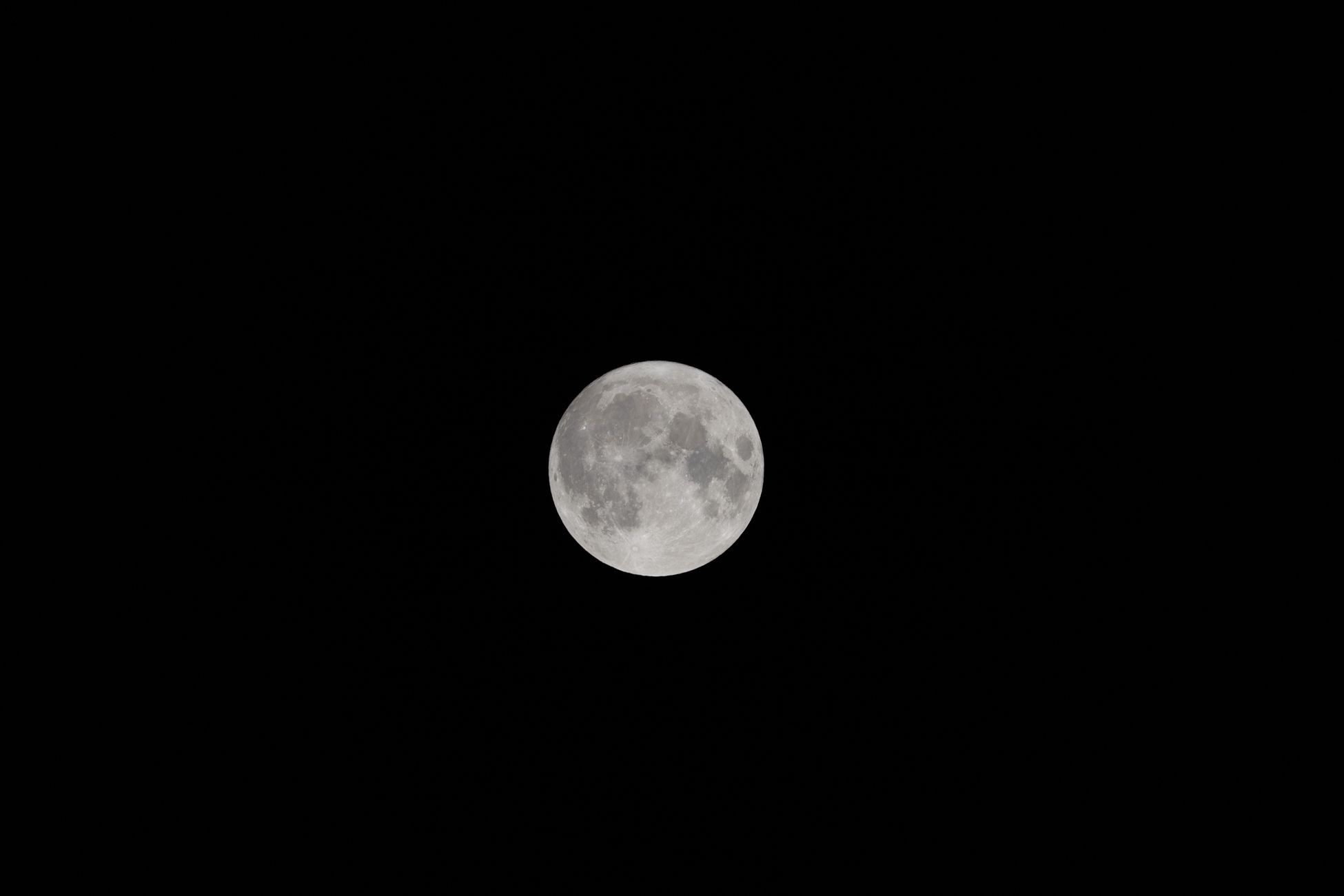 A striking image of the full moon glowing brightly against a dark night sky, highlighting its craters and surface details.